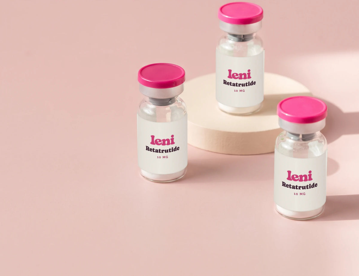 Three Leni vials arranged in a loose triangle on a blush backdrop.